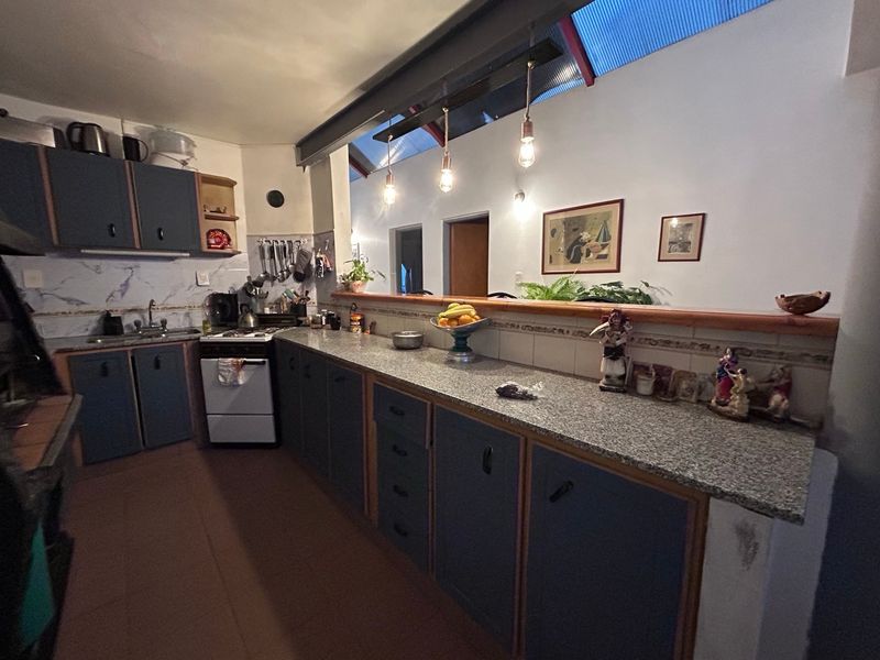 Cocina con muebles azul grisáceo y mesada de granito
