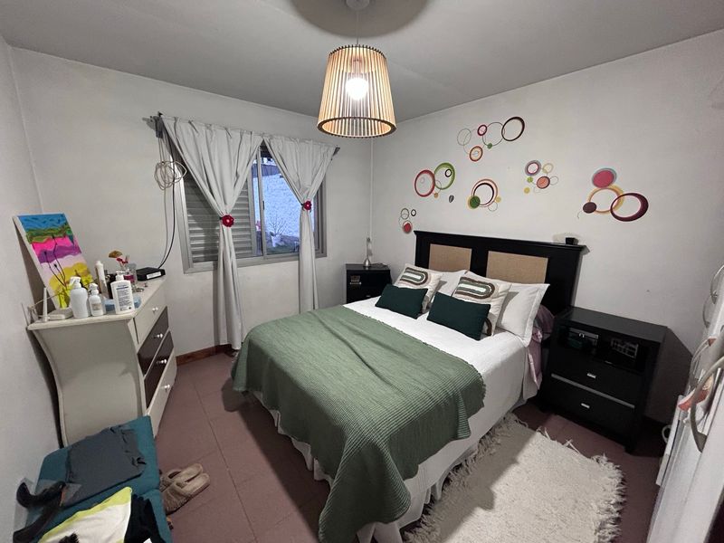 Dormitorio con cama de dos plazas y lámpara de mimbre